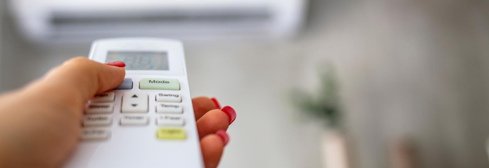 person using a remote to control an indoor air conditioner