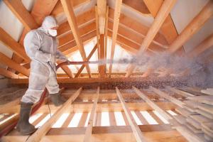 man insulating a home's attic