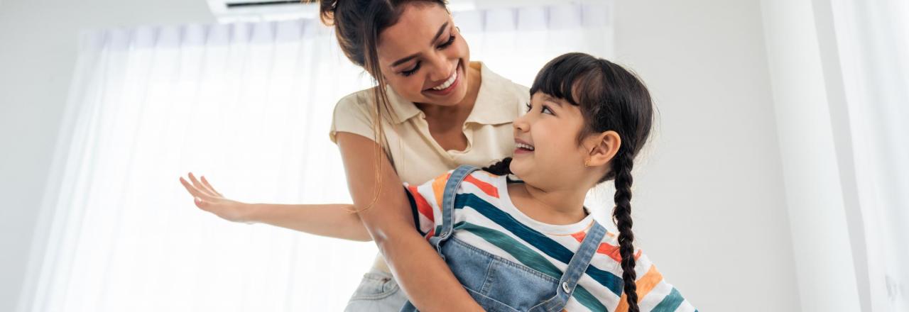 woman and child hugging in front of a heat pump