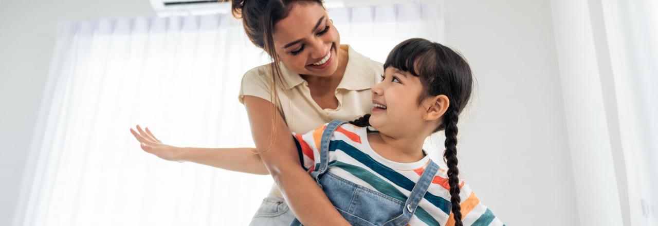 woman and child hugging in front of a heat pump