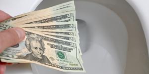 A hand throwing money down your toilet