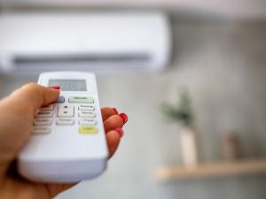 person using a remote to control an indoor air conditioner