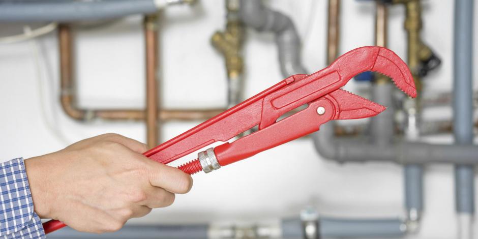 wrench being held by repairman getting ready to service air conditioner