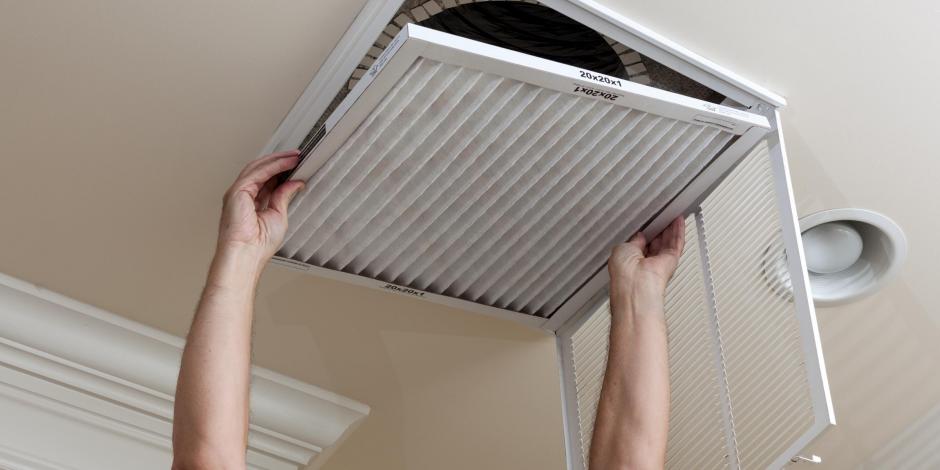 man replacing central air air filter