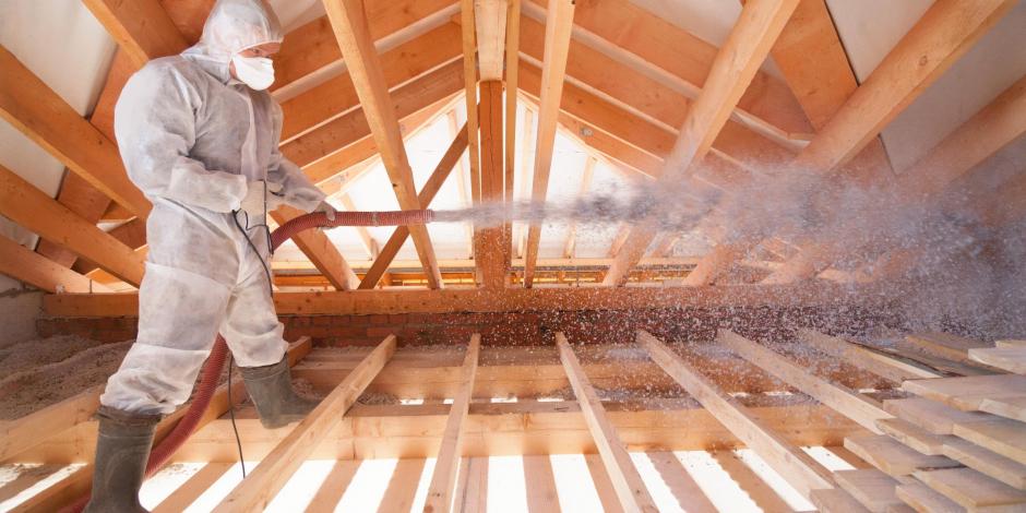 man insulating a home's attic