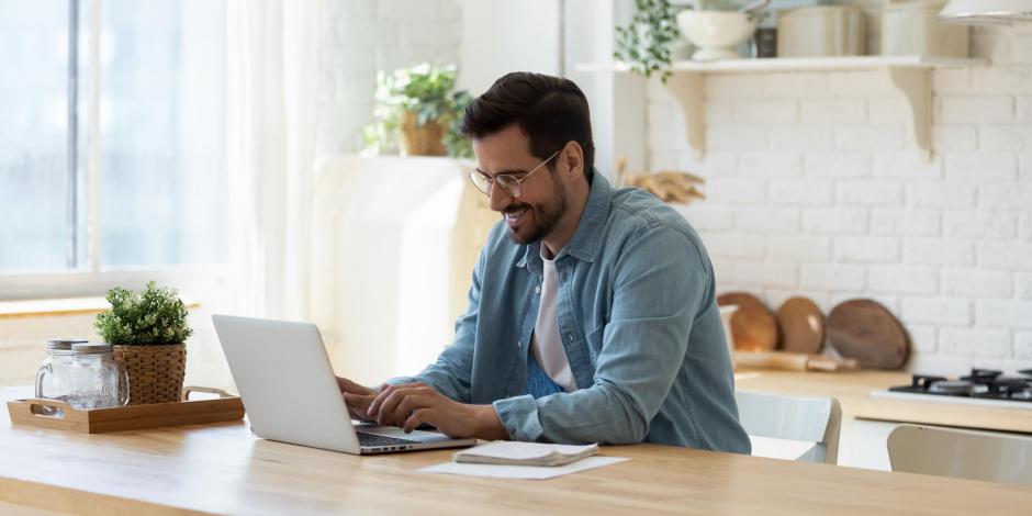 Man on a computer in a kitchen