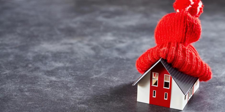 A toy house with a red knit hat